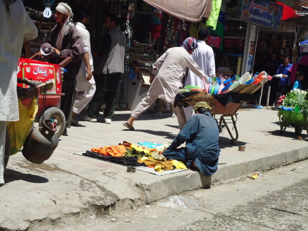 Merchant putting out his wares on the sidewalk of Makroyan market