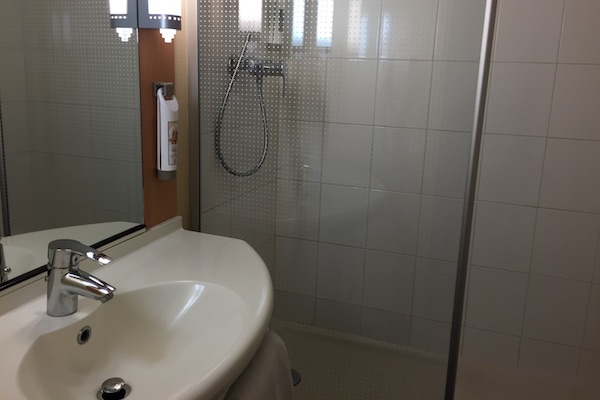 Bathroom sink and shower at Hotel Ibis Calais