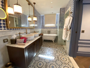 Bathroom with ornate tile floors, brown sink and a clawfoot tub