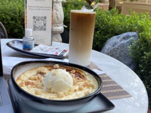 Rice pudding topped with ice cream, next to an iced latte