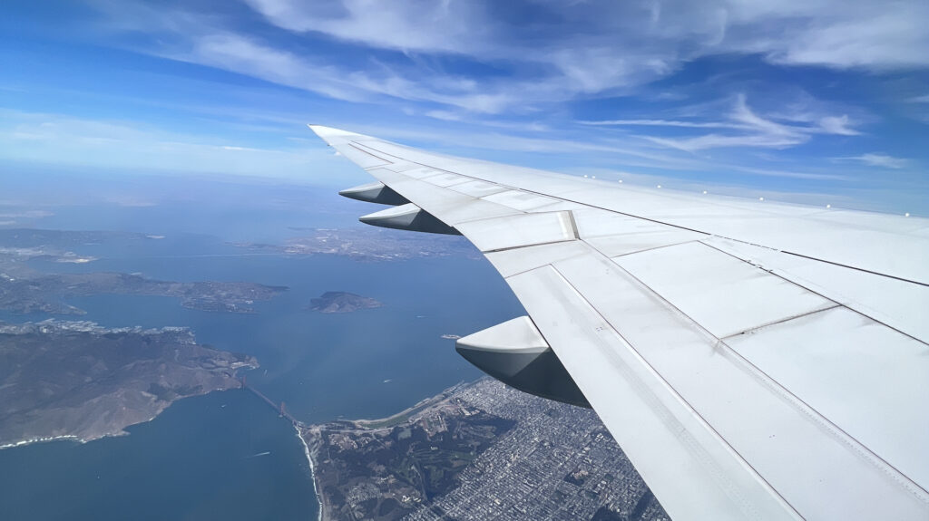 Airplane wing over a city