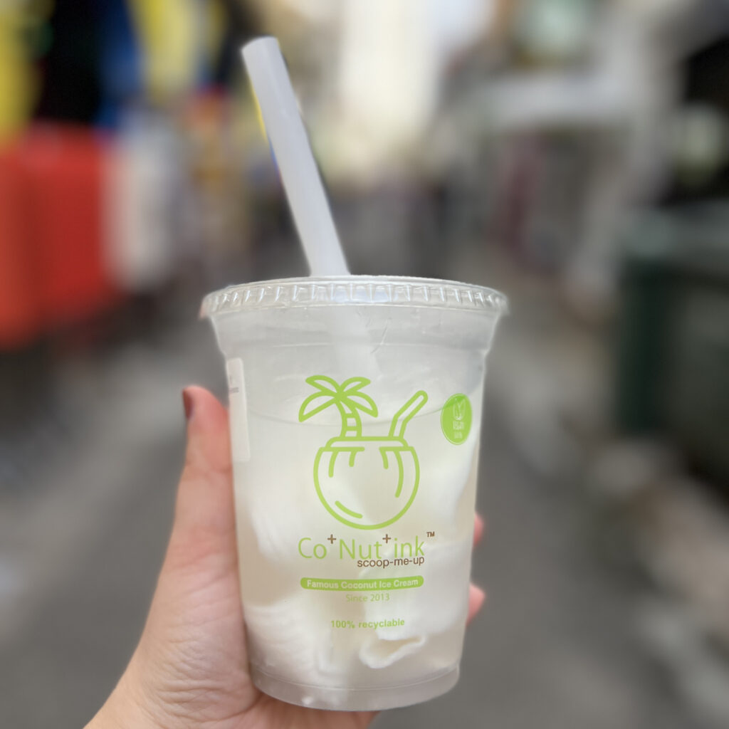 Cup of coconut water with coconut shavings inside