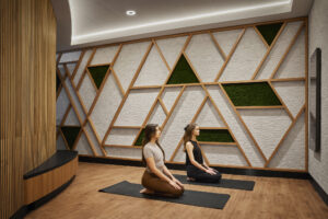 Two women sitting on mats in a room at The Club at SFO