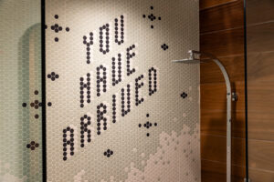 Shower with tiles spelling out "you have arrived."