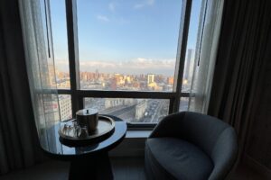 A window with a table and chair overlooking the Manhattan Bridge arch in NYC